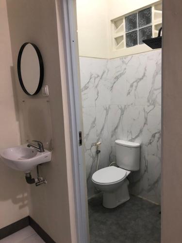 a bathroom with a white toilet and a sink at Bernice Homestay Syariah 1 Wonosobo in Wonosobo