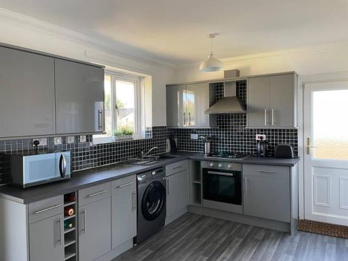 a kitchen with a sink and a dishwasher at 3 bedroom detached house, close to Glasgow in Barrhead
