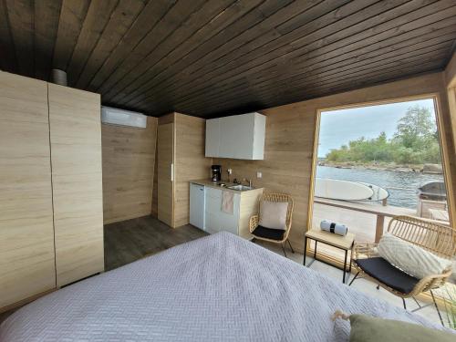 a bedroom with a bed and a view of the water at Mökkilautta in Kalajoki