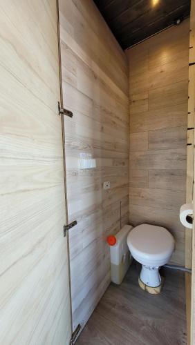 a bathroom with a toilet in a wooden wall at Mökkilautta in Kalajoki