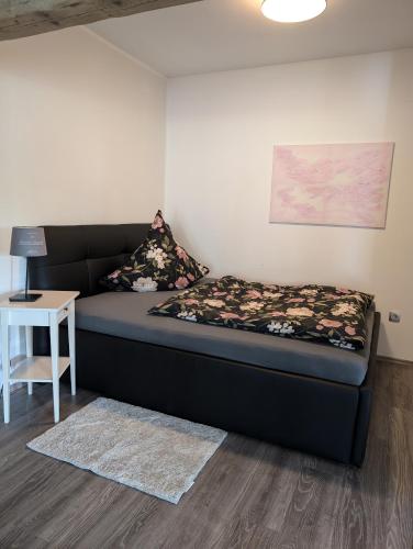 a small bed in a room with a table at Ferienwohnung zum Hühnerstall in Förbau