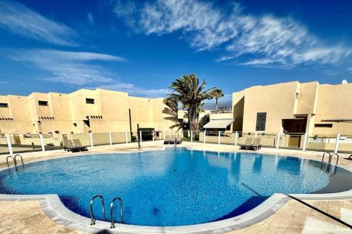 a large swimming pool in front of a building at Sol & Mar in El Médano