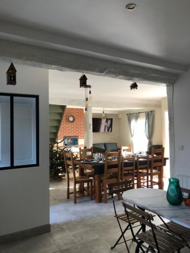 une salle à manger et un salon avec une table et des chaises dans l'établissement Domaine de Praline - Le potager de Justin, à Villerbon