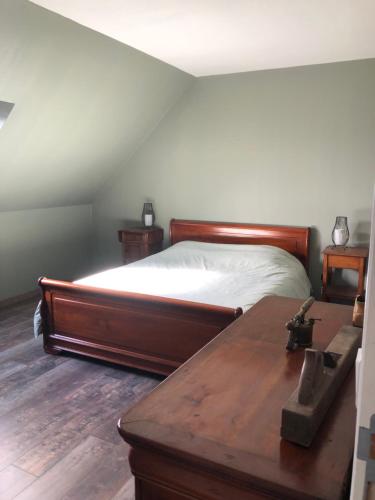 a bedroom with a bed and a wooden table at Domaine de Praline - Le potager de Justin in Villerbon