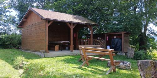 eine kleine Holzhütte mit einer Bank im Gras in der Unterkunft Chata Rossa in Králíky