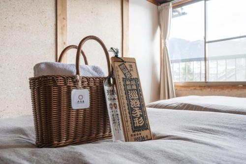 a wicker basket sitting on top of a bed at Shibuonsen House in Yamanouchi