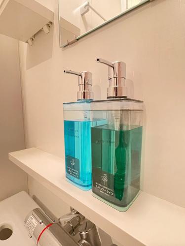 two soap dispensers sitting on a shelf in a bathroom at 1101 札幌中心部 アクセス最高 すすきの駅より徒歩5分 in Sapporo
