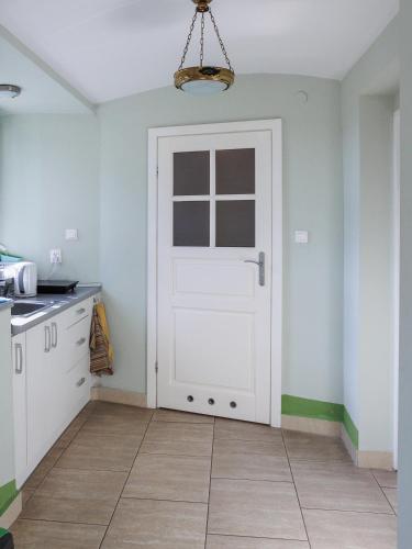 a kitchen with a white door in a room at Zamość Dwór Udrycze in Udrycze