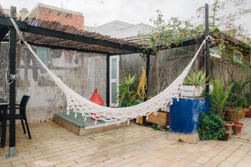 a hammock hanging from a pergola on a patio at Casa Caracol in Cádiz