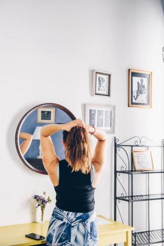 a woman standing in front of a mirror at Casa Caracol in Cádiz