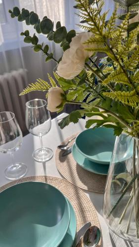 a table with blue plates and a vase with flowers at Heron in Tychy