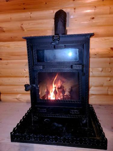 a fireplace in a room with a fire in it at არწივის ბუდე eagle's nest in Goderdzi