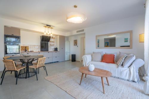 un salon avec un canapé blanc et une table dans l'établissement Magnifique appartement niché dans une pinède, à Sanary-sur-Mer