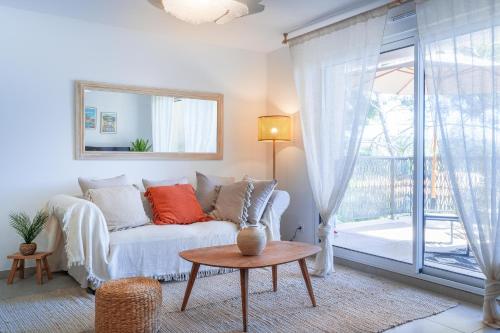 un salon avec un canapé et une table dans l'établissement Magnifique appartement niché dans une pinède, à Sanary-sur-Mer