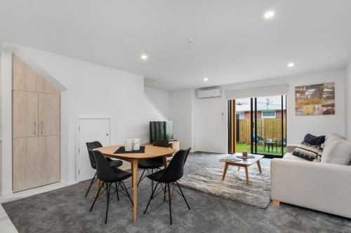 a living room with a table and chairs and a couch at Prime Location Cosy Warm Free Off Street Park in Addington