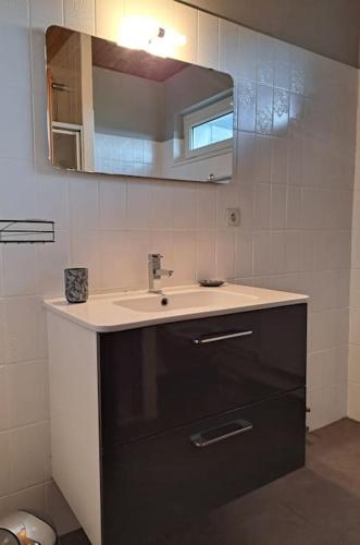 une salle de bain avec un lavabo et un miroir dans l'établissement Maison La Roche du Miroir, à Plaimbois-du Miroir