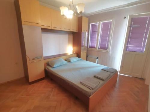 a bedroom with a large bed with blue pillows at J Family Budget in Vidin