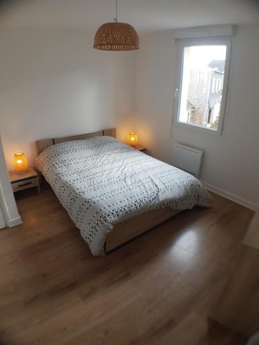 une chambre avec un lit dans une pièce avec une fenêtre dans l'établissement Le Julianais, à Saint-Julien