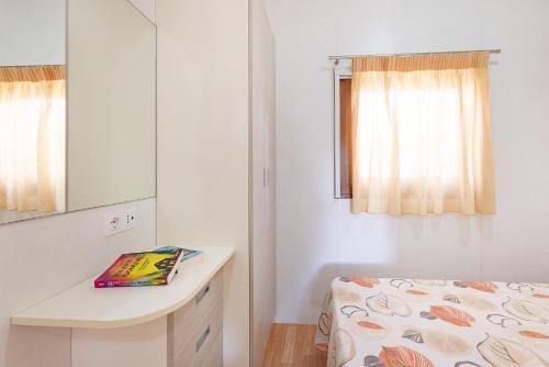 a bedroom with a bed and a desk and a mirror at Camping Bungalow Lido in Capoliveri