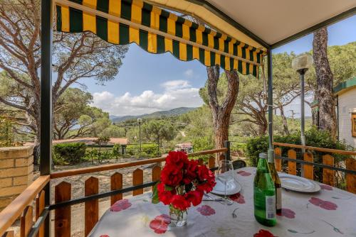 a table with a vase of flowers on a balcony at Camping Bungalow Lido in Capoliveri