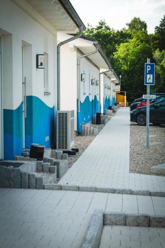 a building with blue and white walls and a parking lot at Pension am Park in Rust