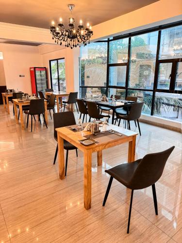 a dining room with tables and chairs and a chandelier at Hotel Omni Residency Baridhara in Dhaka
