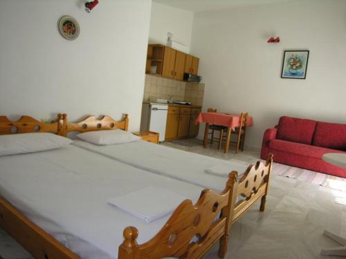 a bedroom with a large bed and a red couch at Astoria Keramoti Paralia beach in Keramotí