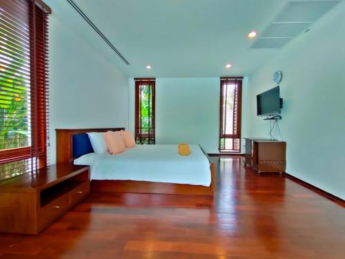 a bedroom with a bed and a tv in it at Pranaluxe 4 Bedroom Pool Villa C6 in Pran Buri