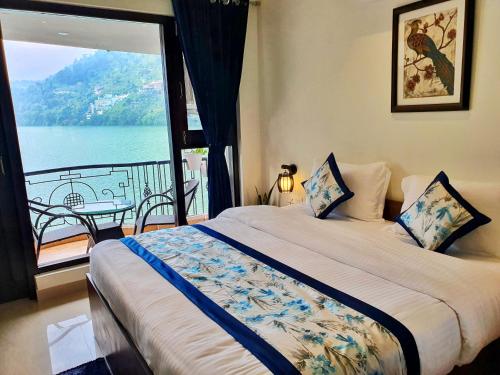 a bedroom with a bed with a view of the water at The Lake Hill in Nainital