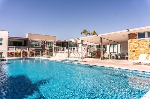 a swimming pool in front of a building at Pavilion Palm Beach, Vibrant Cafés Beach & Dining in Gold Coast