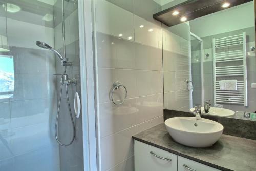 a white bathroom with a sink and a shower at Sainte-Foy Station, Appartement 2 chambres rénové, Vue vallée, Skis aux pieds in Sainte-Foy-Tarentaise