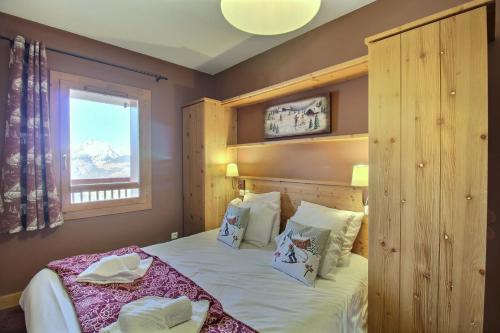 a bedroom with a large bed and a window at Sainte-Foy Station, Appartement 2 chambres rénové, Vue vallée, Skis aux pieds in Sainte-Foy-Tarentaise