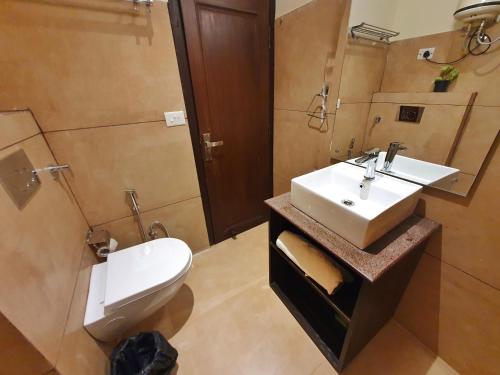 a bathroom with a white sink and a toilet at The Lake Hill in Nainital