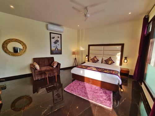 a bedroom with a bed and a chair and a mirror at The Lake Hill in Nainital