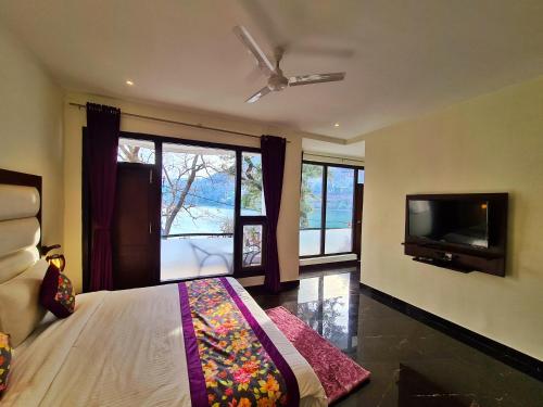 a bedroom with a bed and a flat screen tv at The Lake Hill in Nainital