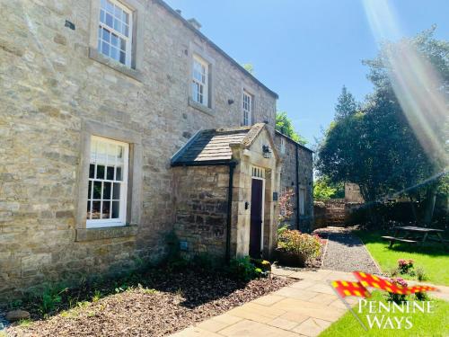an old stone house with a small building at Bridge End House - Pet Friendly in Haltwhistle