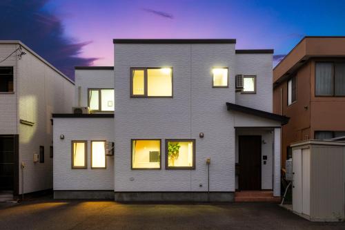 a white house with lights in the windows at The Serenity in Nishi-nijō
