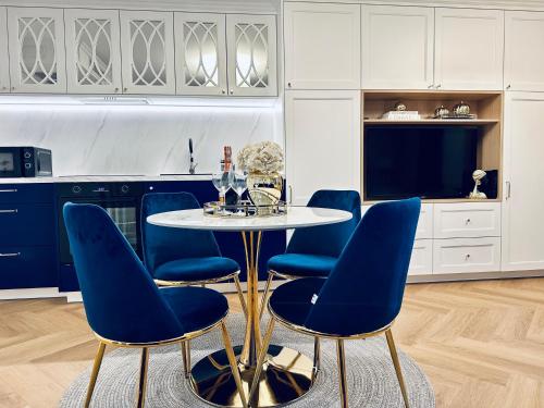 a dining room with blue chairs and a table at Apartament Prosta 28 in Toruń