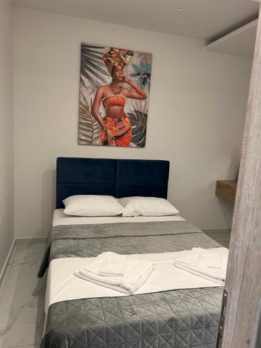 a bedroom with a bed with a painting on the wall at Poseidon 4 in Paralia Katerinis