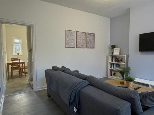 a living room with a couch and a table at Modern Spacious 2 Bedroom House in Leigh, Free Parking in Leigh