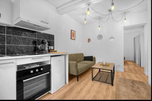 une cuisine et un salon avec un canapé dans l'établissement Grand deux pièces - Proche métro - Terrasse, à Toulouse