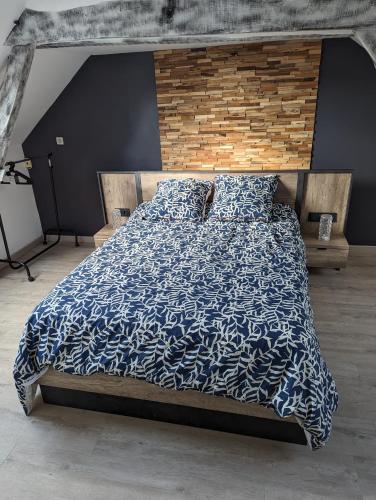 a bed with a blue and white comforter and pillows at Le Bleuet in Spay