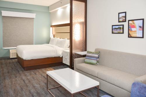 a hotel room with a bed and a couch at Four Points by Sheraton Fayetteville Fort Bragg in Fayetteville