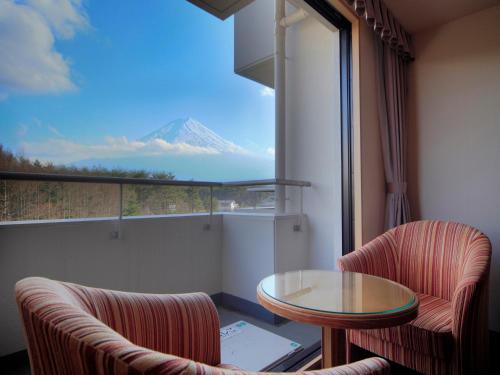 a room with a table and chairs and a view of a mountain at Hotel Regina Kawaguchiko in Fujikawaguchiko