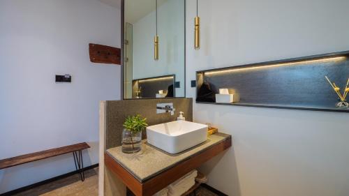 a bathroom with a sink and a mirror at Kong Garden Designer Hotel in Dali Ancient Town