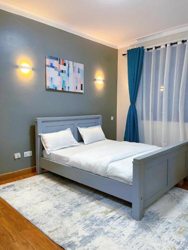 Buwateisaacs appartment的一间卧室配有一张带白色床单和蓝色窗帘的床。