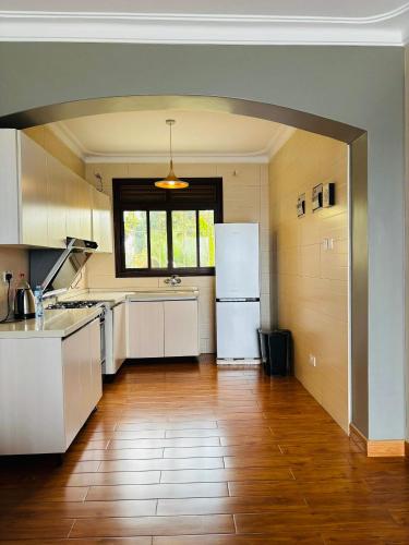 Buwateisaacs appartment的铺有木地板的厨房配有白色家电