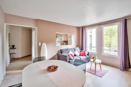 a living room with a couch and a table at Appartement familial proche métro in Créteil