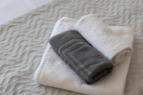 a stack of towels sitting on top of a bed at City Center Apartment IV by Casa D'Oro in Thessaloniki