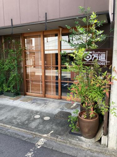 a front door of a building with a plant at Guesthouse Hyakumanben Cross in Kyoto